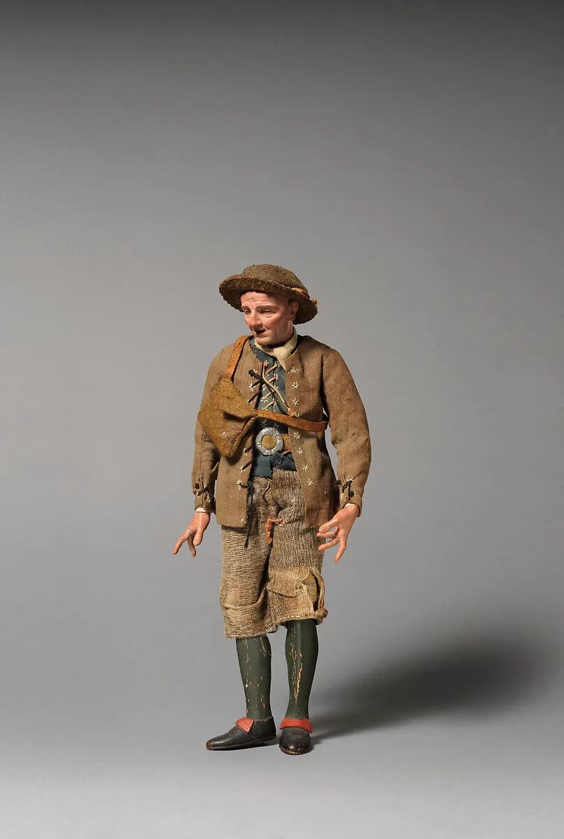 Man in brimmed hat, brown lace-up jacket, green vest, belt buckle, shoulder bag — Unknown