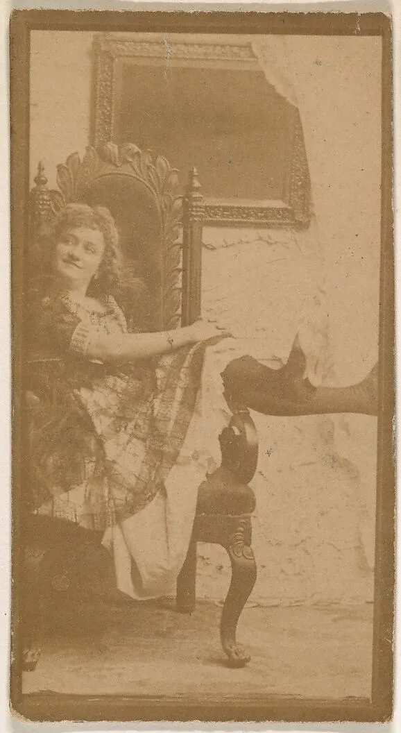 Actress posing on chair with legs resting on armrest, from the Actresses series (N664) promoting Old Fashion Fine Cut Tobacco — Unknown