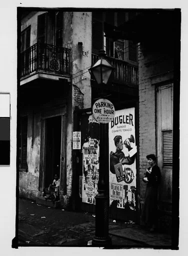 [Jane Ninas on Sidewalk with Boy in Doorway Looking On in French Quarter, New Orleans, Louisiana]