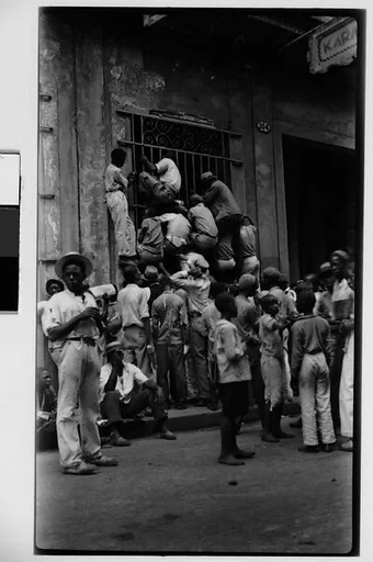 [Newsboys Climbing Iron Grillwork Door, Havana]