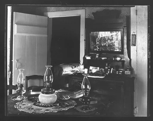 [Interior with Dressing Stand and Table with Three Kerosene Lamps, Possibly Copake, New York]
