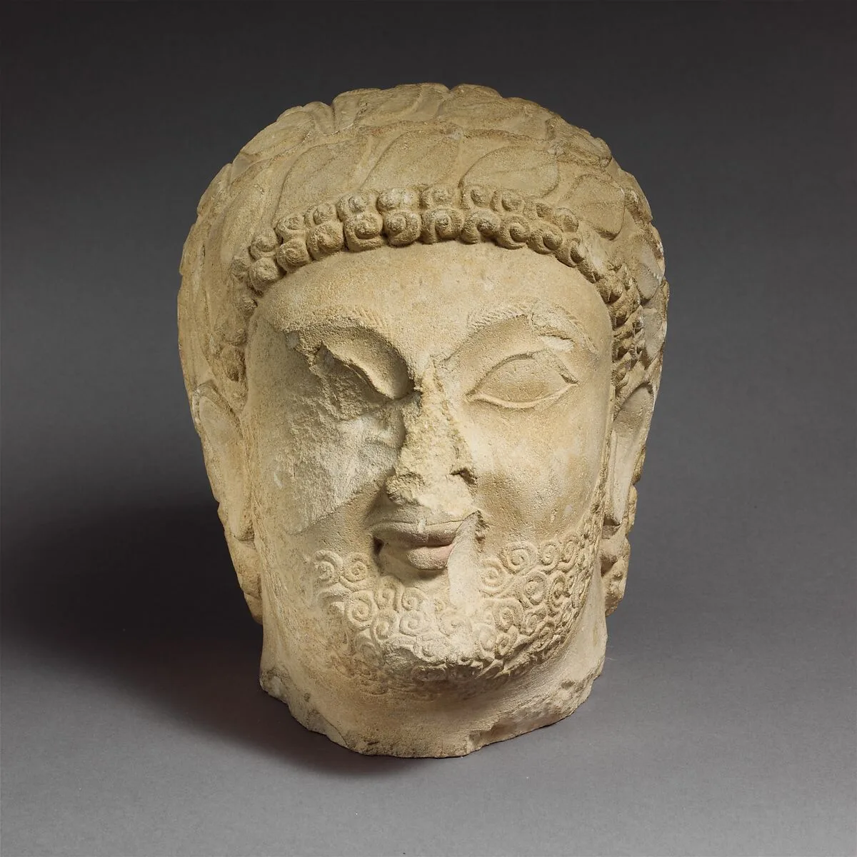 Limestone head of a bearded male with a wreath of leaves — Unknown
