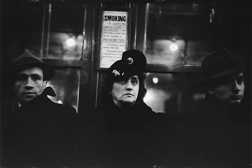 [Two 35mm Film Frames: Subway Passengers, New York City: Woman, Two Men, Young Man in Hat Holding Parcel]