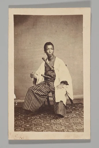 [Studio Portrait: Man Seated with Swords]