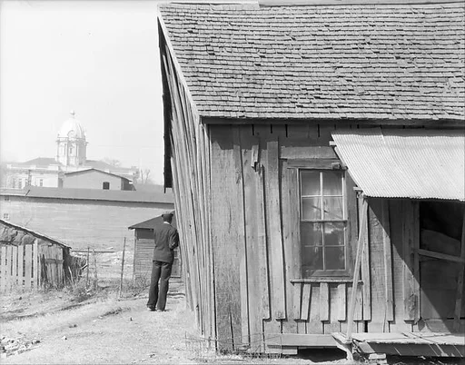 [Man Next to Wooden Shack, Tupelo, Mississippi]