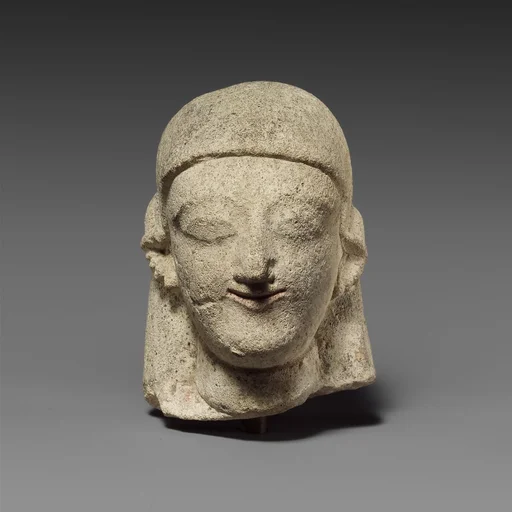 Limestone head of a female with a plain headdress
