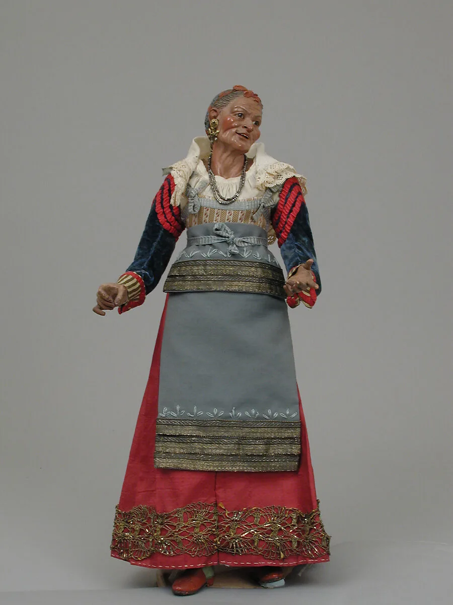 Old woman carrying a wire basket — Unknown