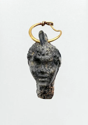 Gold earring with a glass pendant in the shape of a Black African’s head