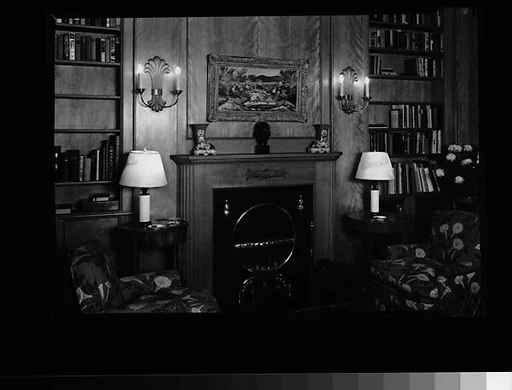 [Library Interior Showing Fireplace with Adjacent Bookshelfs and Armchairs]