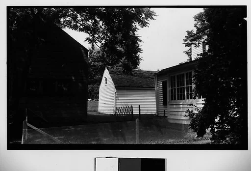 [Clapboard House and Barns Behind Wire Fence]