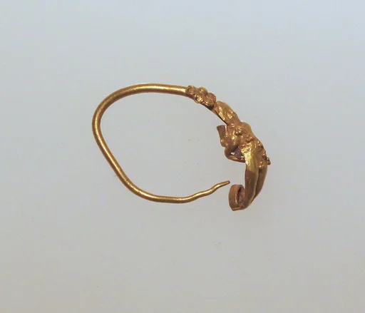 Gold earring with figure