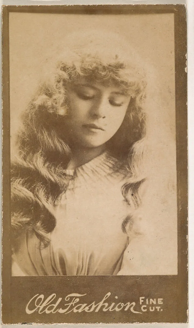 Actress with long wavy hair looking down, from the Actresses series (N664) promoting Old Fashion Fine Cut Tobacco — Unknown