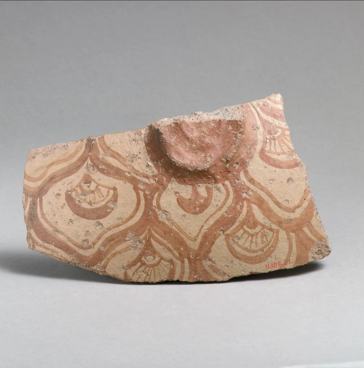 Terracotta vessel fragment with reticulated pattern enclosing conventional flowers — Unknown