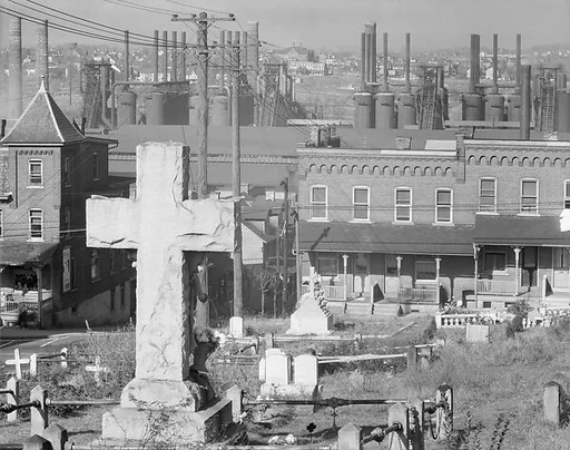 [View of Two-Family Houses and Steel Mill from St. Michael's Graveyard, with Cross Headstone in Foreground, Bethlehem, Pennsylvania]