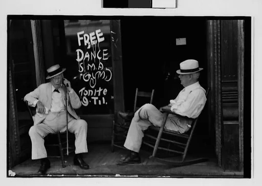 [One 35mm Film Frame: Two Elderly Men in Conversation on Porch in Front of Painted Sign for "Free Dance", Greensboro, Alabama?]