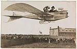 [Couple Flying Airplane Over Crowd]