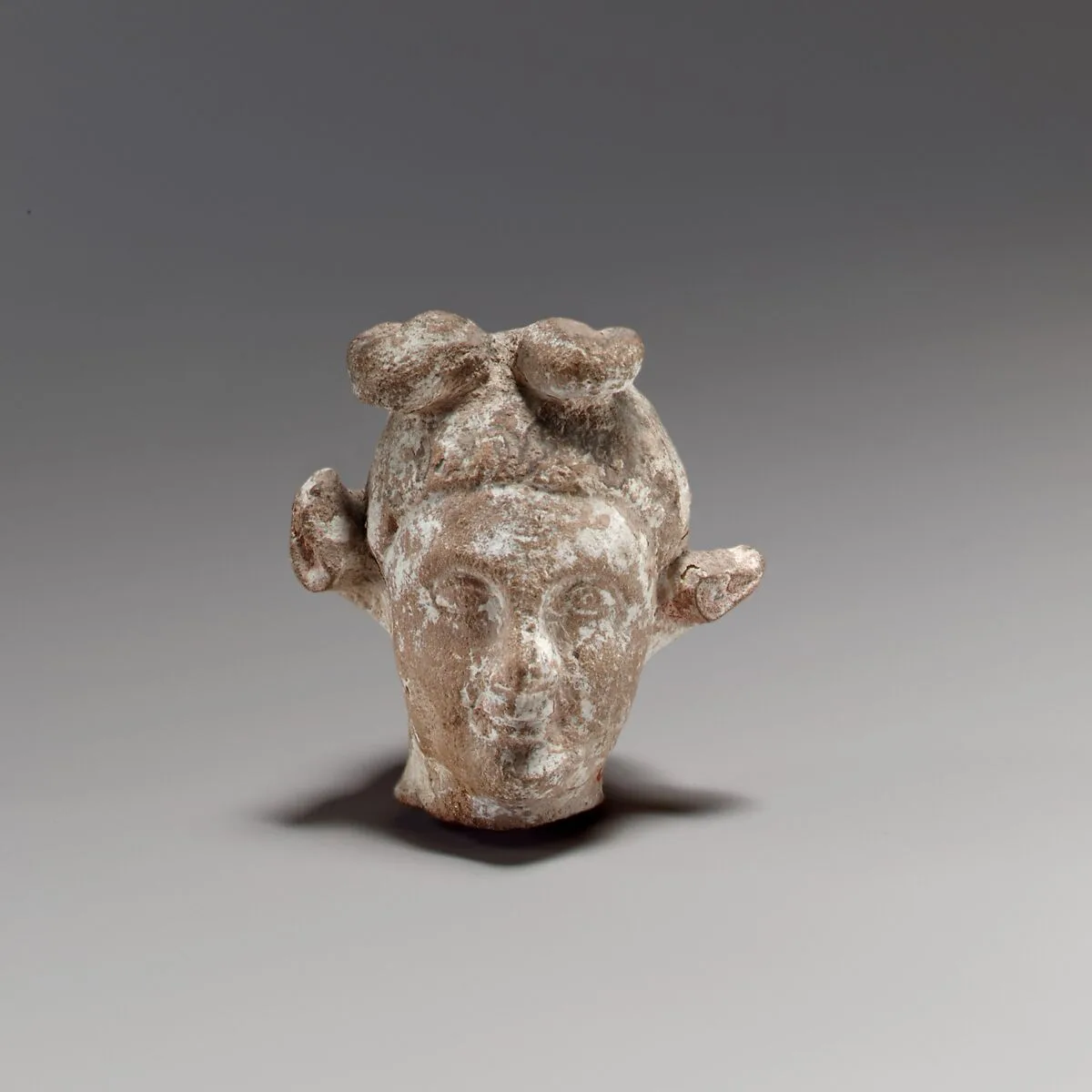 Terracotta head of a youth with a goat headdress — Unknown