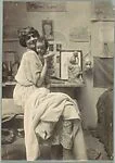 [Woman Holding Baby Before Sculpture and Drawings on Wall]