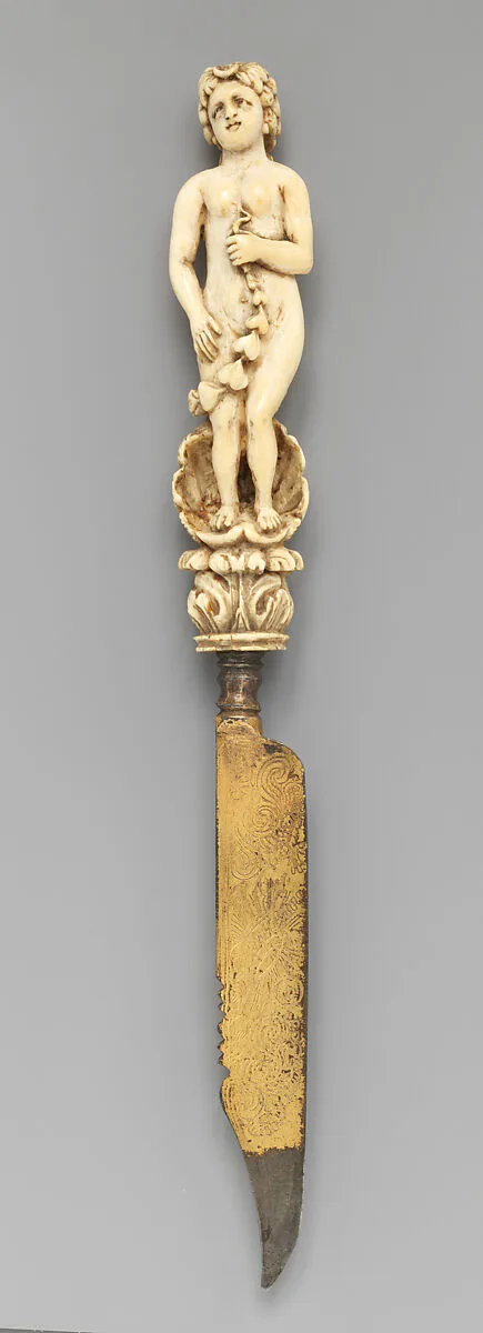 Knife with carved handle of nude female with crescent in hair standing in a half shell holding a swag — Unknown