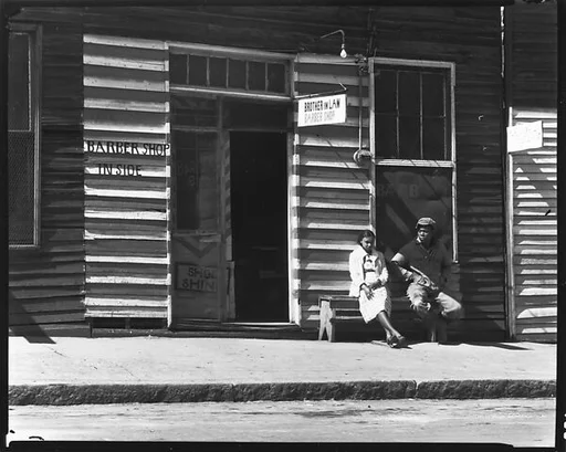[Man and Woman on Bench in Front of Brother-in-Law Barber Shop, Vicksburg, Mississippi]