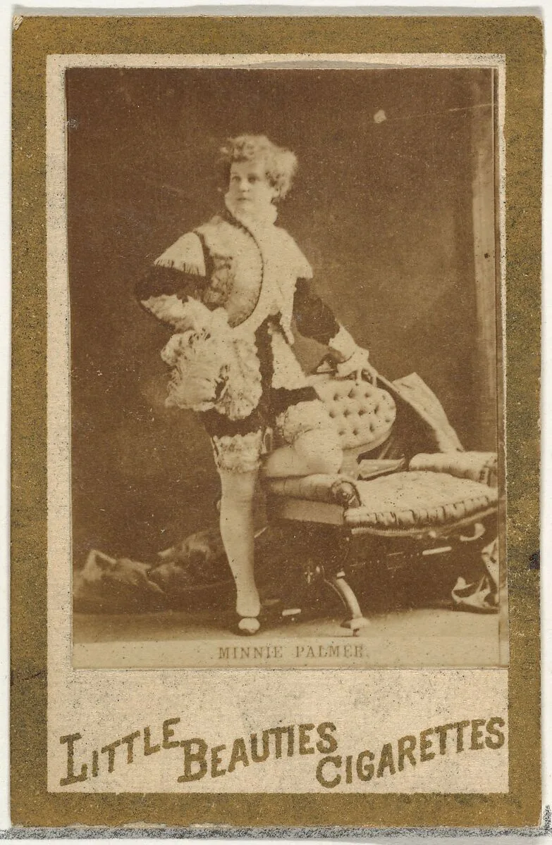 Minnie Palmer (standing beside chair), from the Actresses and Celebrities series (N60, Type 1) promoting Little Beauties Cigarettes for Allen & Ginter brand tobacco products — Allen & Ginter