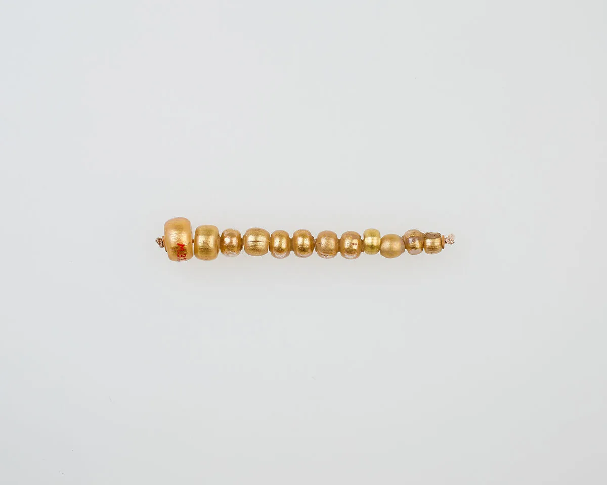 String of 12 elongated disc beads — Unknown