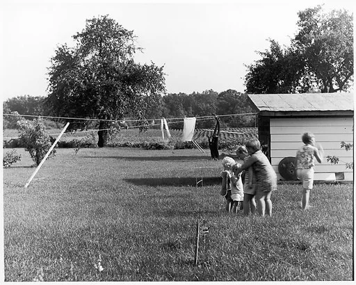[Four Children Huddled Near Clothesline, One Standing Apart]