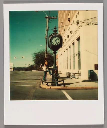 [Two Boys Eating Apples Under Clock Sign On Street Corner]