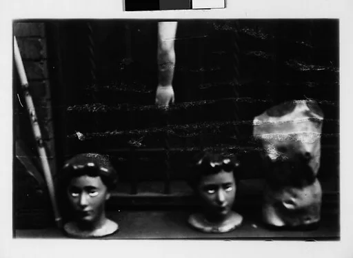 [Two 35mm Film Frames: Window Ledge Display on Street of Wax Votive Candle and Statuettes, New York City]