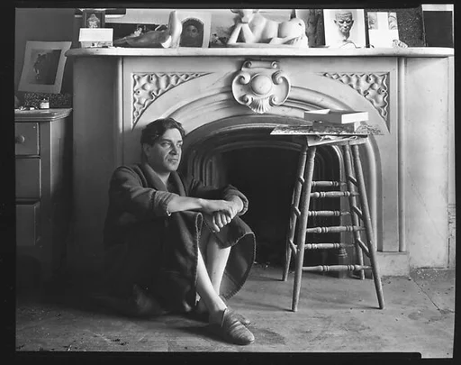 [Reuben Nakian Seated in Front of Fireplace Mantle]