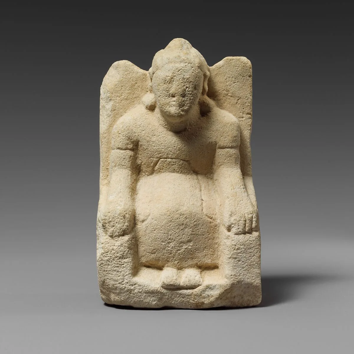 Limestone statuette of a seated beardless male votary with a helmet — Unknown