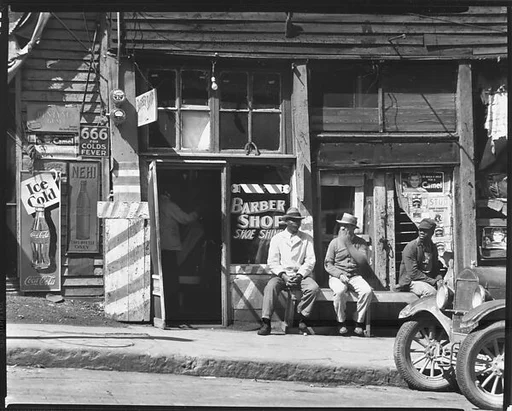 [Men Seated on Bench in Front of Barber Shop, Vicksburg, Mississippi]