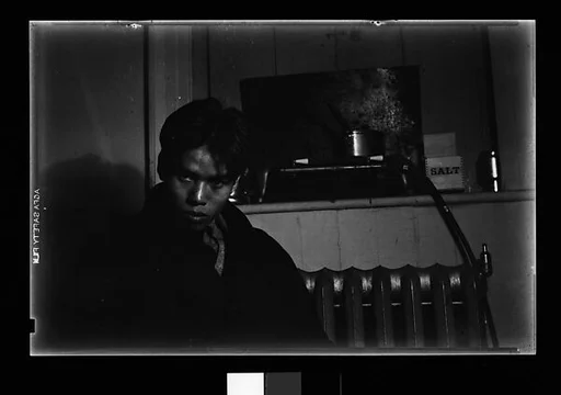 [Young Man in Overcoat Seated in Front of Radiator]
