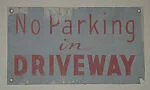 [Metal Sign: "No Parking in Driveway"]