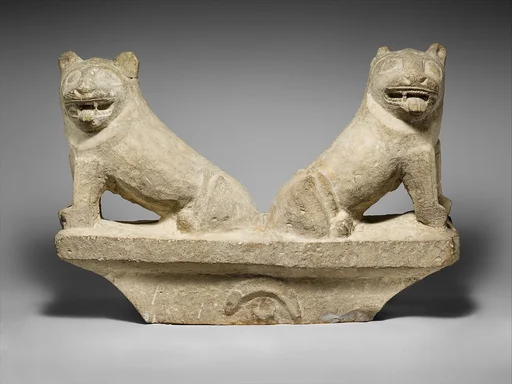 Limestone finial of a funerary stele with two seated lions