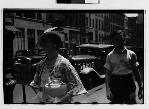 [Two 35mm Film Frames: Woman Passing Taxistand on Street, New York City]