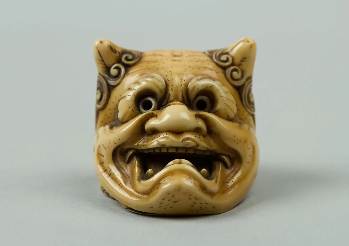 鬼面下の阿亀牙彫根付 銘:民谷|Netsuke of Okame under a Demon Mask — Unknown