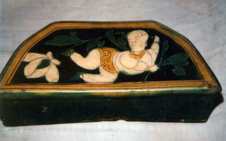 金 河津窯三彩刻花執荷童子紋枕|Pillow with a boy holding a lotus — Unknown