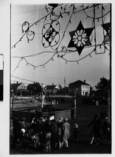 [Three 35mm Film Frames: Fairground Scenes with Hanging Electric Lights and Children on Swing Set]