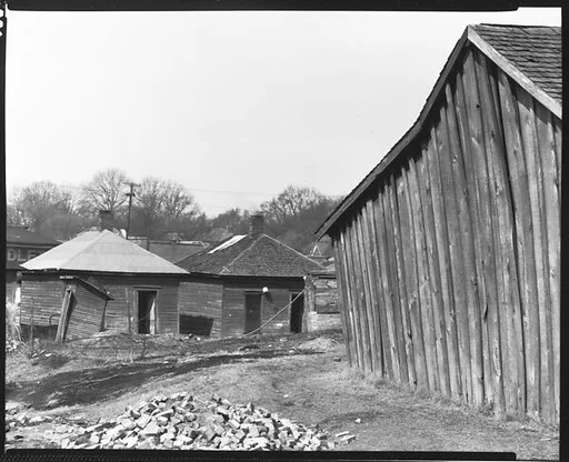 [Wooden Houses with Pile of Bricks in Foreground, Tupelo, Mississippi]