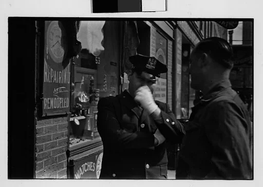 [Two 35mm Film Frames: Man and Policeman on Street Outside Watch Repair Shop, New York City]