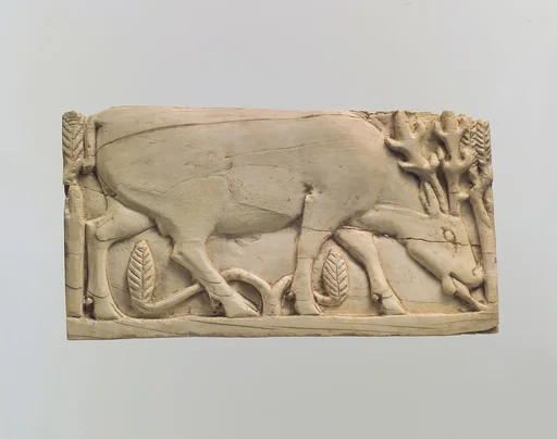 Furniture plaque carved in relief with a stag grazing among plants