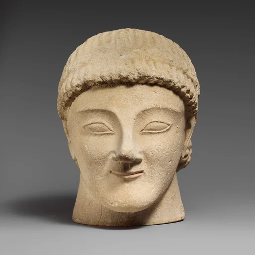 Limestone head of a beardless male votary with a wreath of rosettes