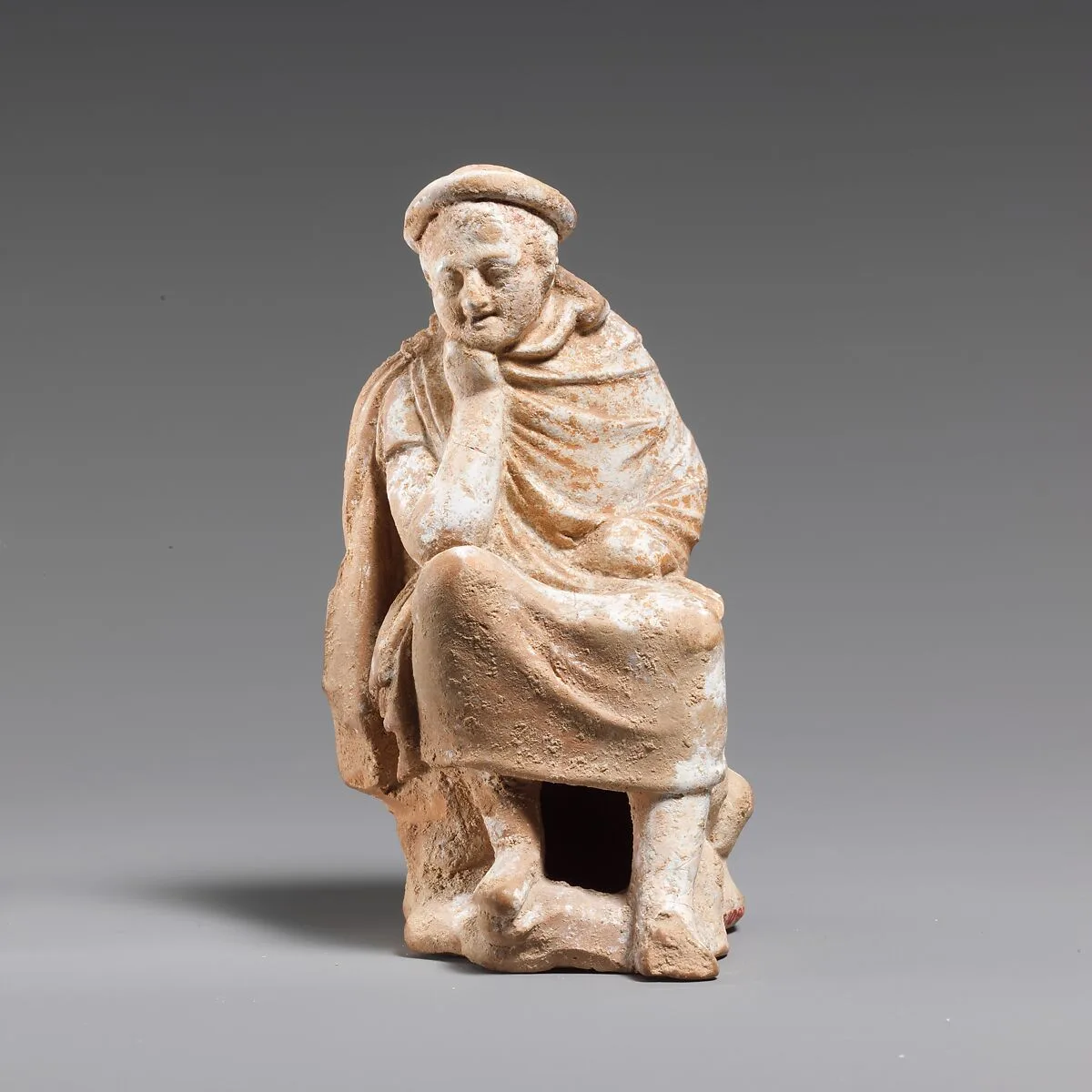 Terracotta statuette of a youth seated on a rock — Unknown