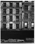 [Façade of Brick Buildings with Loading Dock Below]