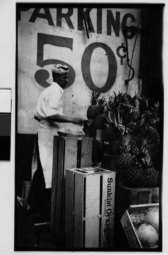 [Worker Unloading Pineapples from Crates, New York City]