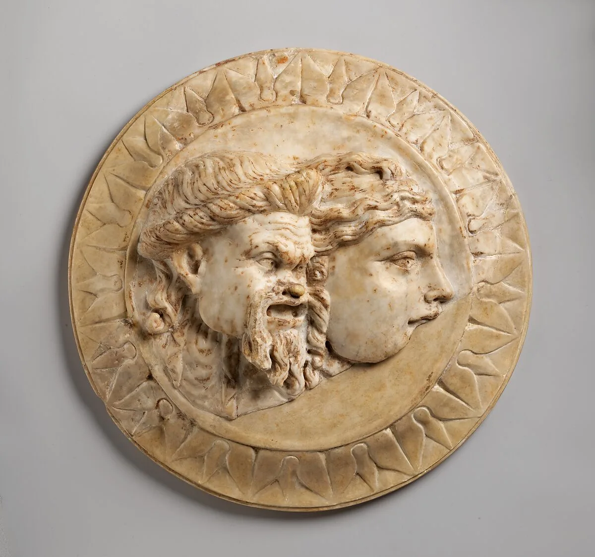Marble disk with two theater masks in relief — Unknown
