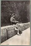 [Woman Seated on Ledge against Brick Wall, Cartagena, Spain]