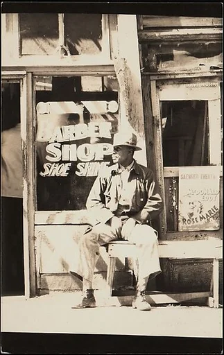 [Man Seated Outside Barber Shop, Vicksburg, Mississippi]
