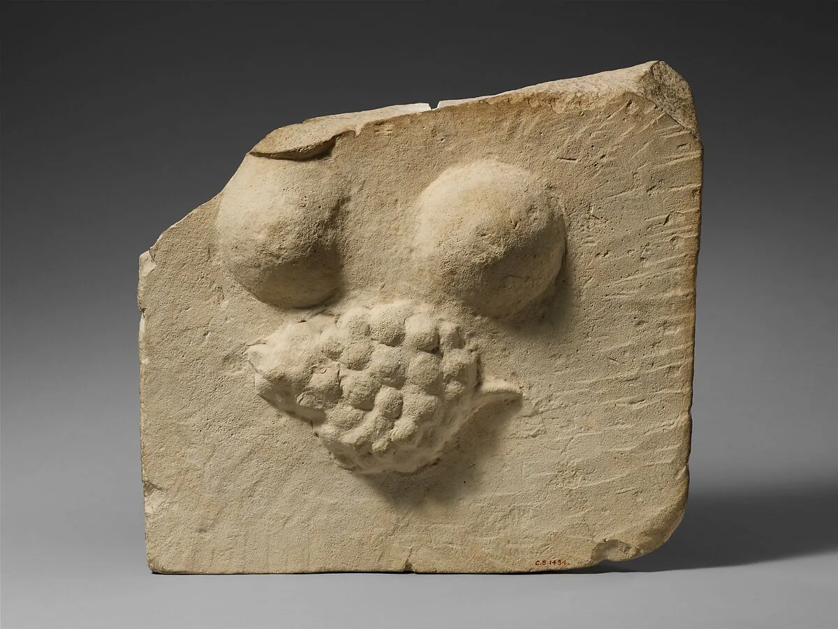 Limestone plaque with breasts and a bunch of grapes in relief — Unknown